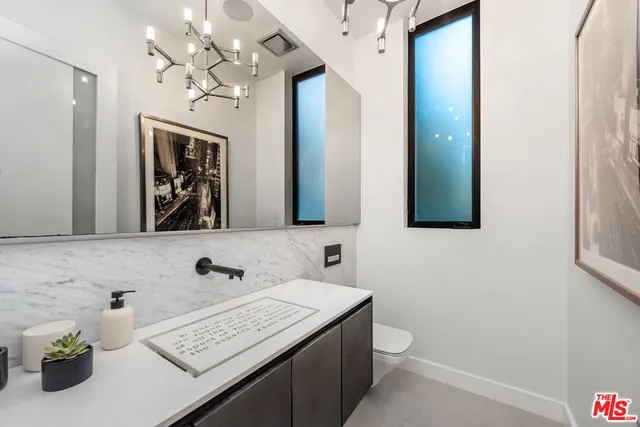 a bathroom with a toilet a sink and a mirror