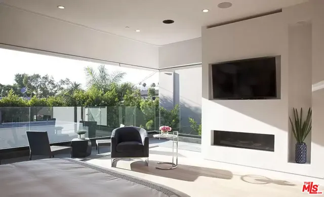 a living room with patio furniture and a flat screen tv