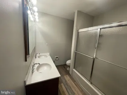 a bathroom with a sink and glass door shower
