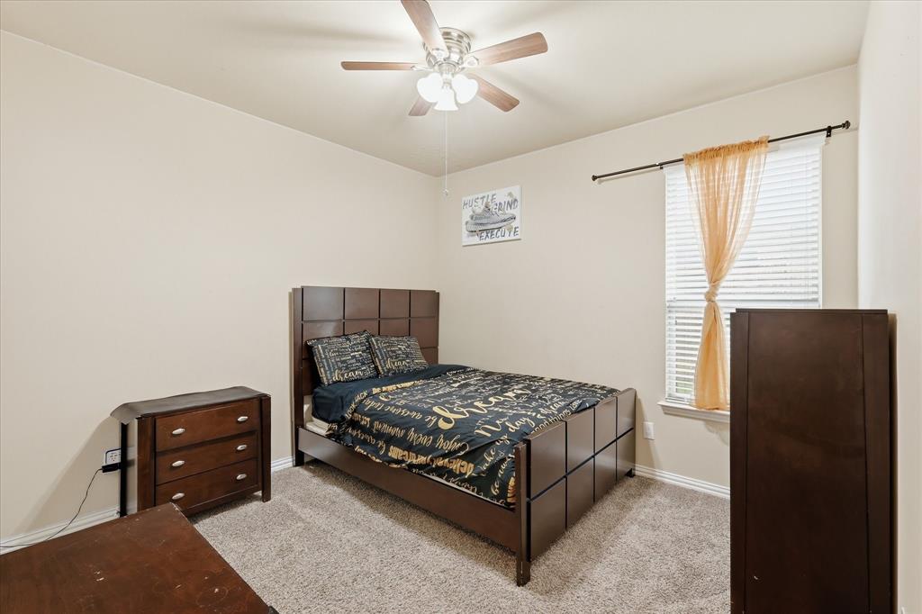 215 Equestrian Road Hickory Creek, TX 75065 - Photo 22 of 36 a bedroom with a bed and a chandelier