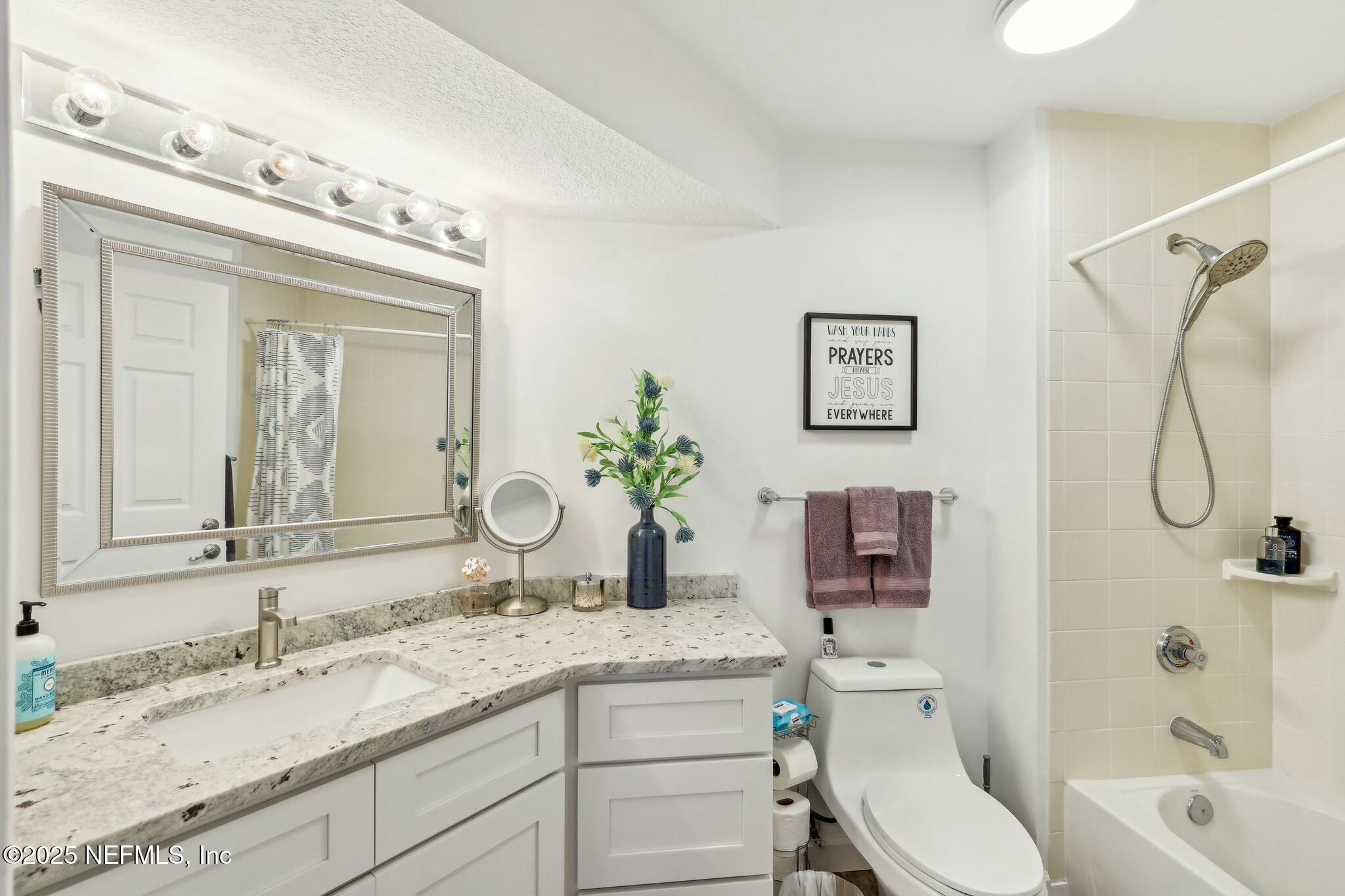 2102 Vista Cove Road St. Augustine, FL 32084 - Photo 22 of 40 a bathroom with a granite countertop sink a toilet and a mirror