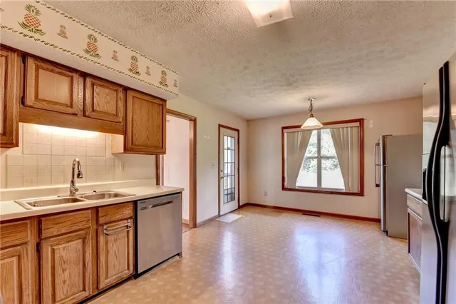 a kitchen with stainless steel appliances granite countertop a sink a stove and a wooden floors