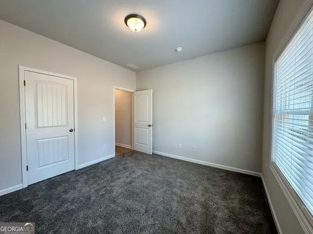 an empty room with an entryway and window view