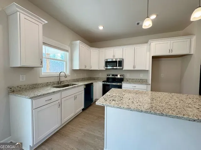 a large kitchen with stainless steel appliances kitchen island a large counter top and a stove