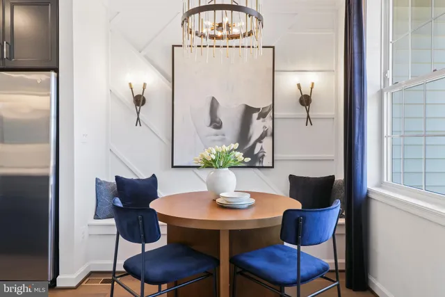 a view of a dining room with furniture a chandelier and wooden floor