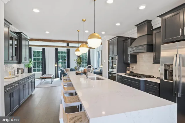 a kitchen with stainless steel appliances granite countertop a kitchen island a stove a refrigerator a oven a large island with wooden floor and cabinets