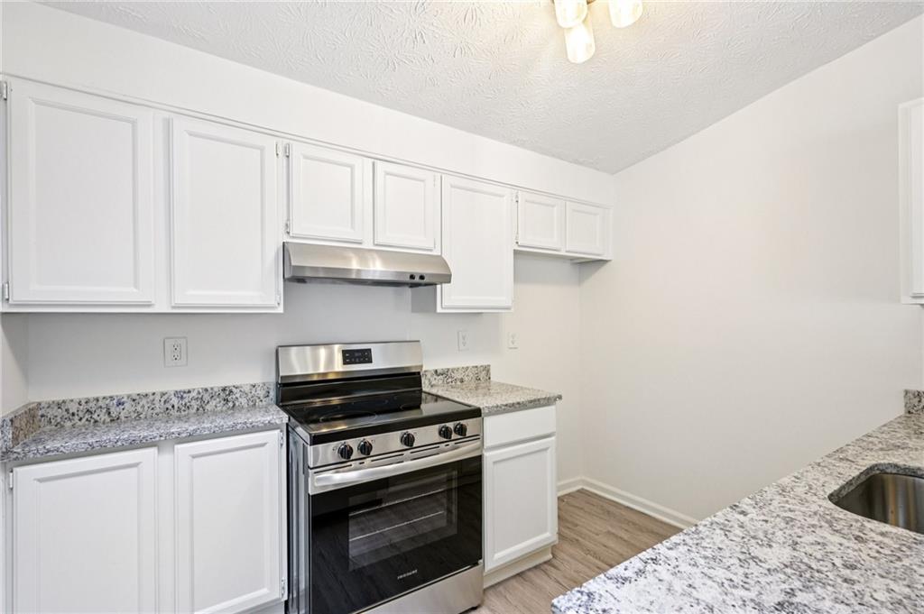 4263 Parkview Court Stone Mountain, GA 30083 - Photo 12 of 31 a kitchen with granite countertop a stove a sink and dishwasher