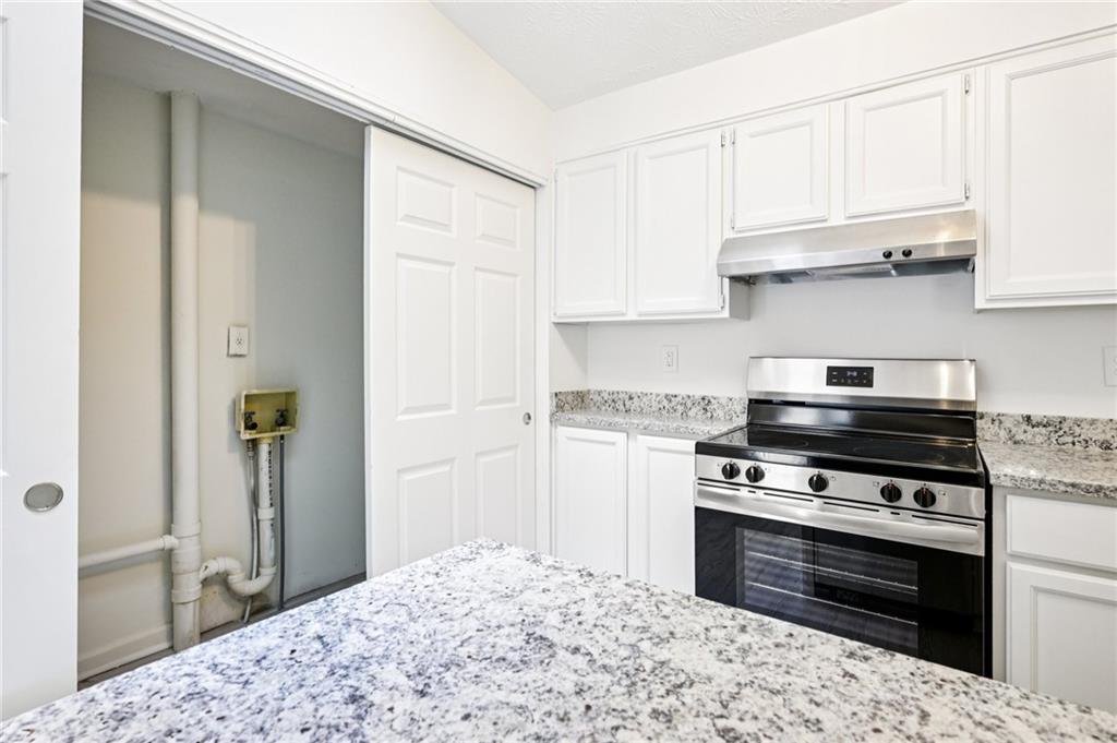 4263 Parkview Court Stone Mountain, GA 30083 - Photo 15 of 31 a kitchen with kitchen island granite countertop a stove cabinets and refrigerator