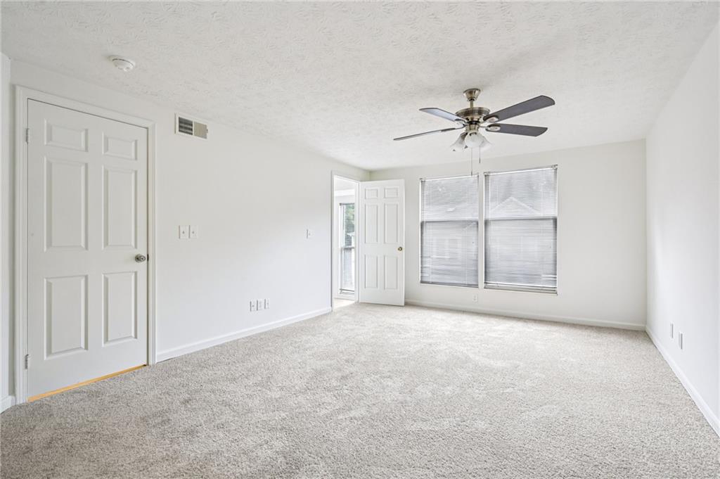 4263 Parkview Court Stone Mountain, GA 30083 - Photo 20 of 31 an empty room with chandelier fan and windows