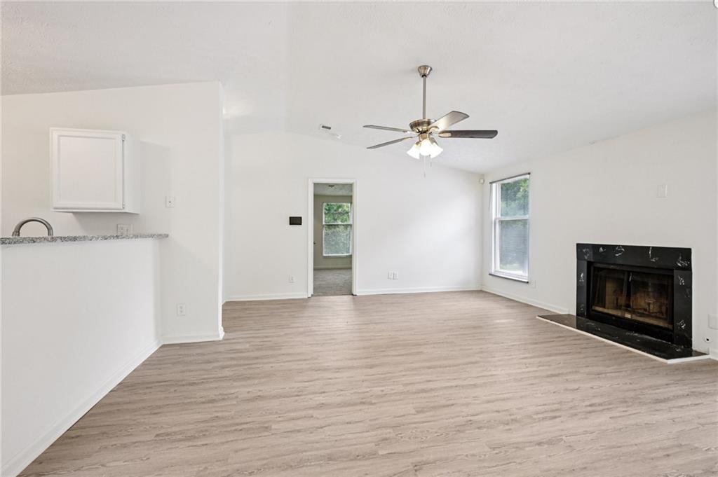 4263 Parkview Court Stone Mountain, GA 30083 - Photo 8 of 31 a view of a livingroom with a fireplace a ceiling fan and wooden floor