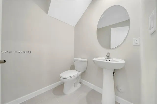 a bathroom with a sink toilet and a mirror