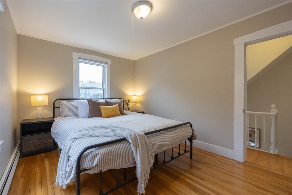 12 1st Street, Unit 12 Ipswich, MA 01938 - Photo 22 of 42 a bedroom with a bed and wooden floor