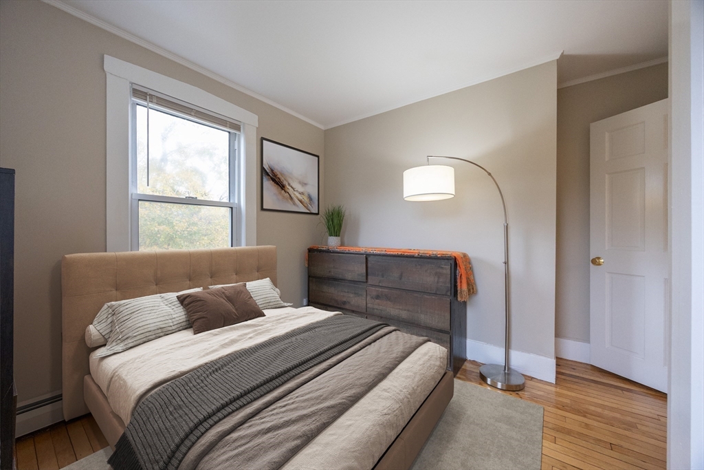 12 1st Street, Unit 12 Ipswich, MA 01938 - Photo 26 of 42 a bedroom with a bed and a large mirror next to a window