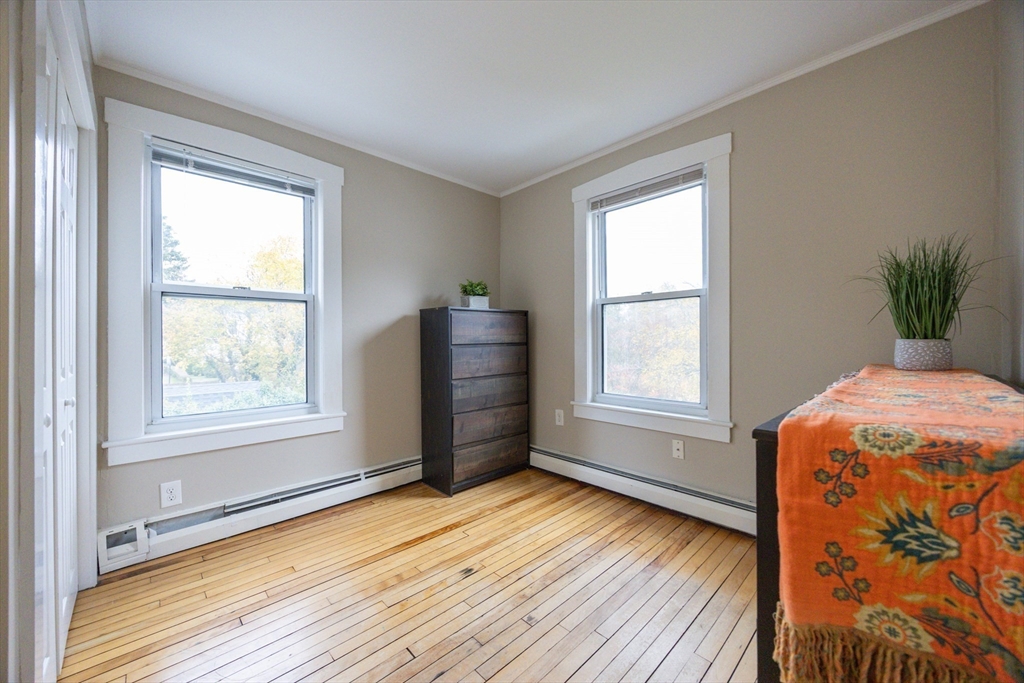 12 1st Street, Unit 12 Ipswich, MA 01938 - Photo 28 of 42 a view of an empty room with a window and wooden floor