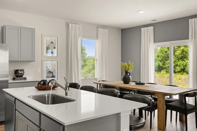 a kitchen with a dining table chairs and wooden floor