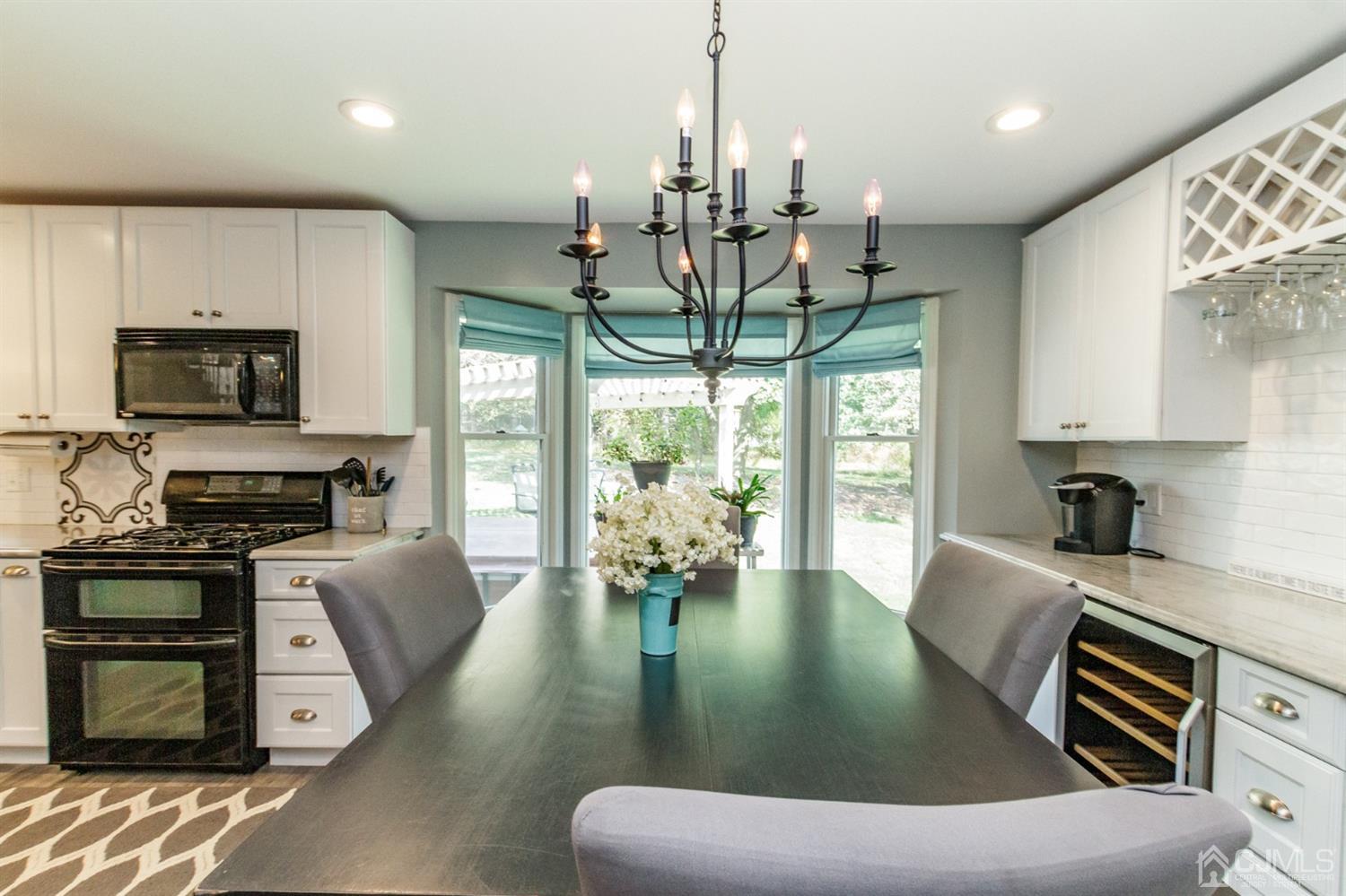 66 Rustic Trail Flemington, NJ 08822 - Photo 7 of 37 a large kitchen with stainless steel appliances granite countertop a stove a refrigerator a sink a dining table and chairs with wooden floor