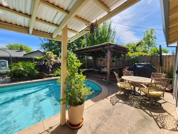a view of a patio with table and chairs potted plants