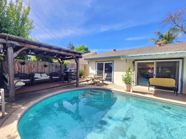 a view of a house with swimming pool and sitting area