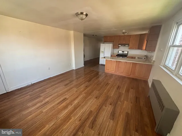 a kitchen with granite countertop wooden floors a stove and a refrigerator