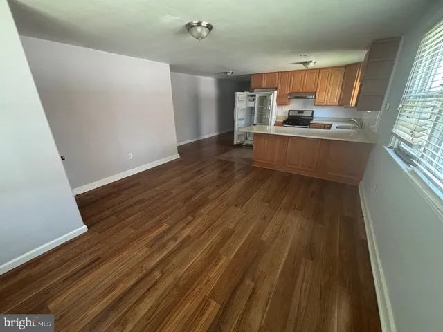 a kitchen with kitchen island wooden floors and stainless steel appliances