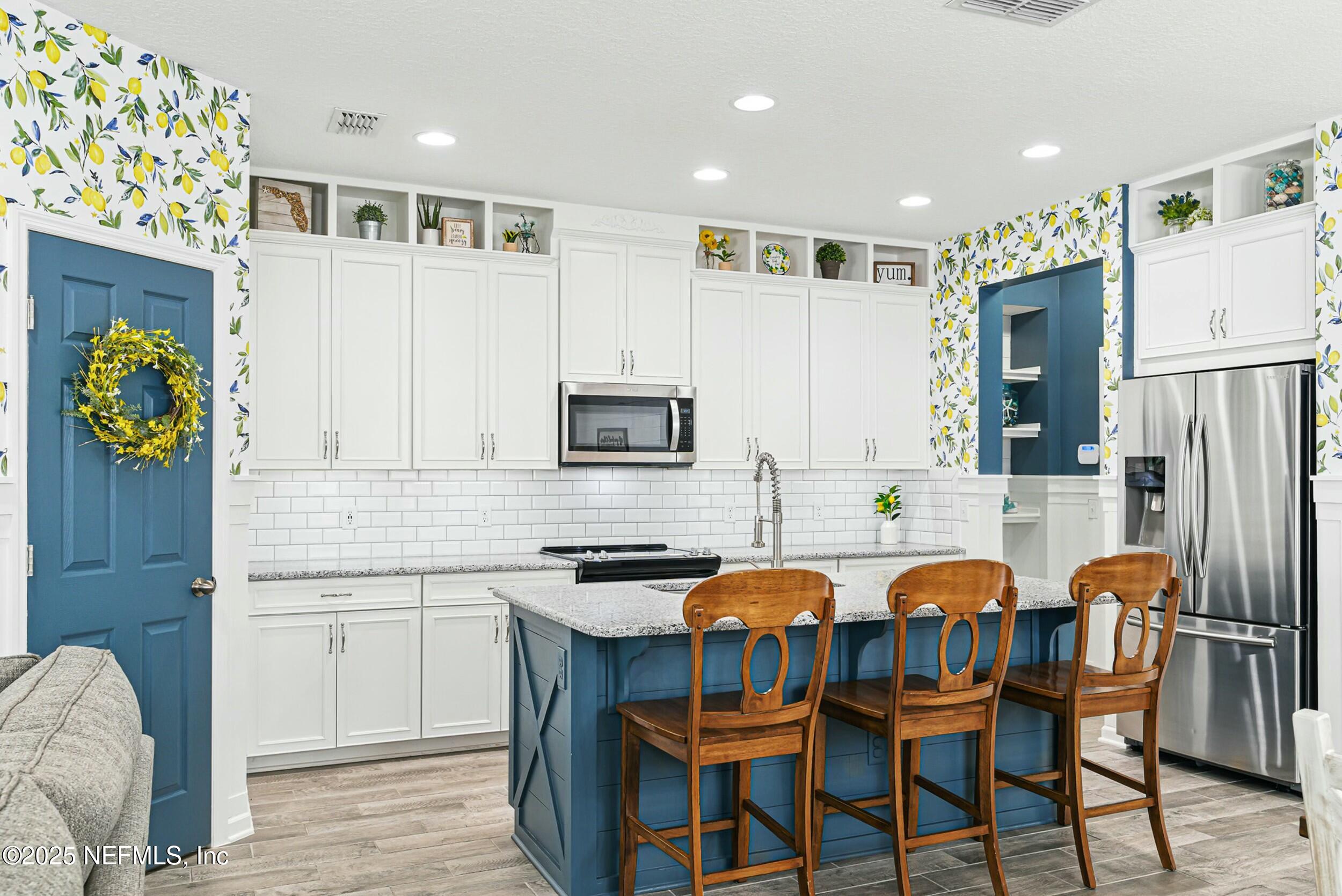 30 Cloverbrook Road St. Johns, FL 32259 - Photo 4 of 69 a kitchen with stainless steel appliances a dining table chairs refrigerator and sink