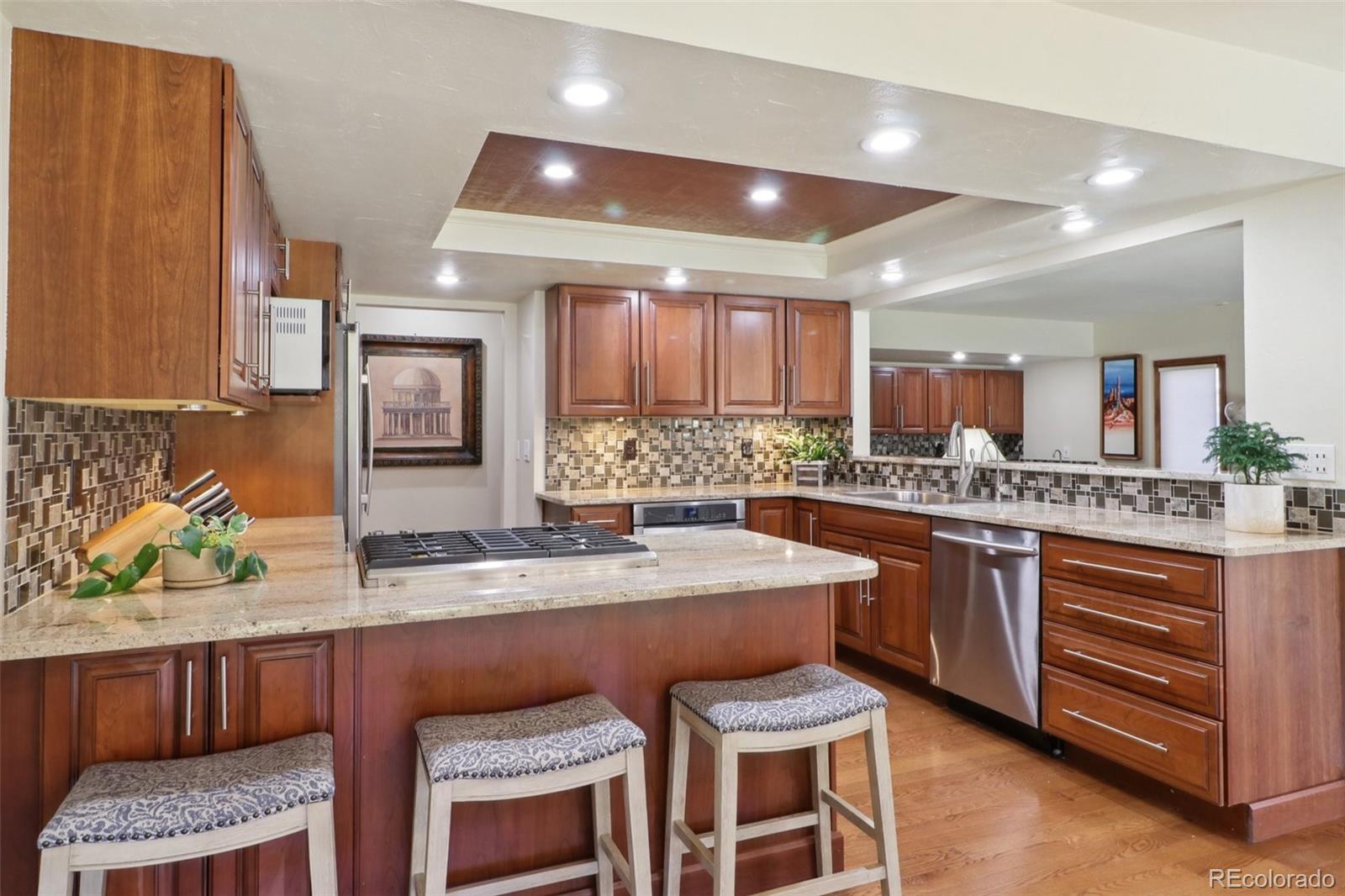 a kitchen with stainless steel appliances granite countertop wooden cabinets a stove a sink and a granite counter tops