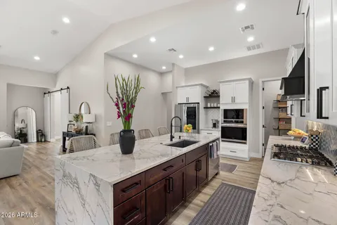 a large kitchen with a counter space a sink and living room view
