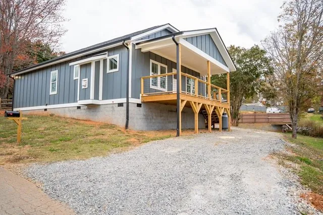 a front view of a house with a yard and trees