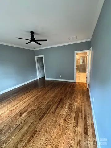 a view of a big room with wooden floor and windows