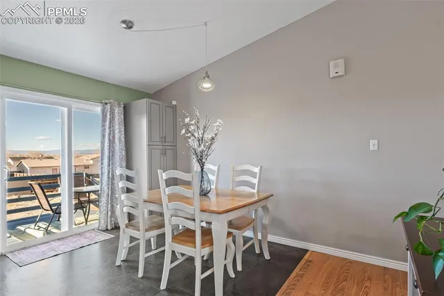 a room with table chairs and wooden floor