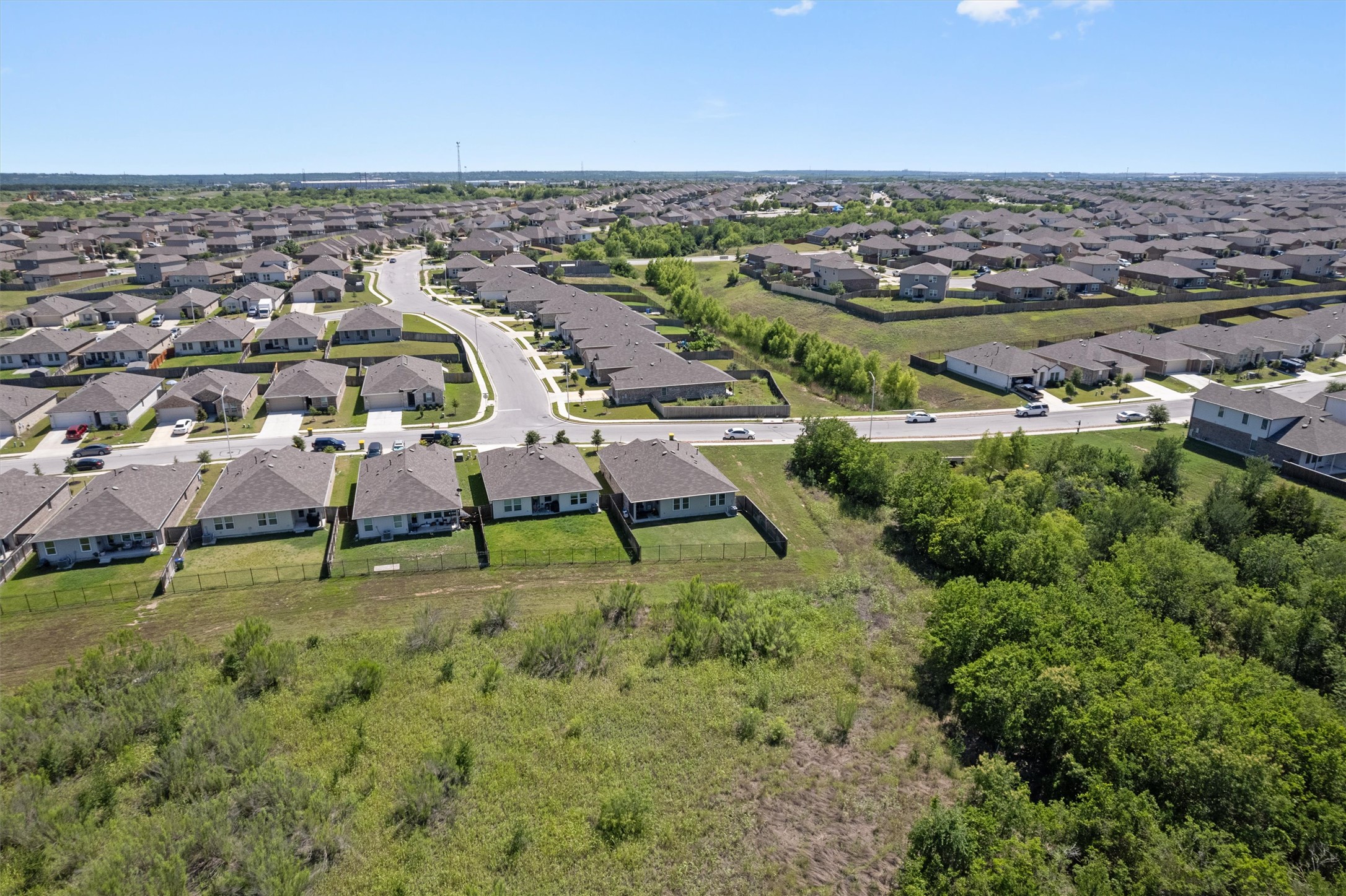 19912 Abigail Fillmore Road Manor, TX 78653 - Photo 27 of 31 An aerial perspective reveals a vast neighborhood layout with verdant undeveloped land nearby.