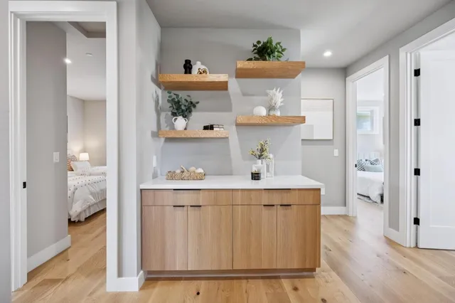 a view of kitchen with stainless steel appliances a table and wooden floor