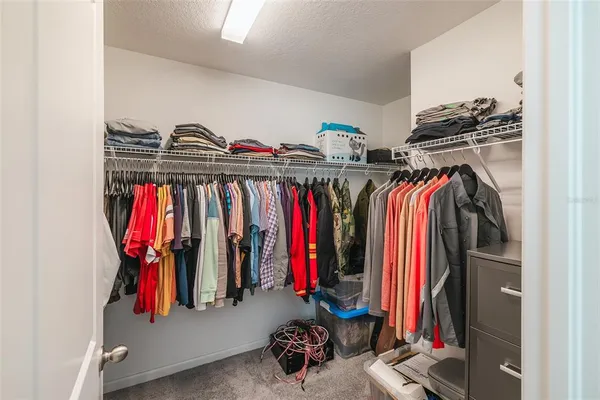 a view of walk in closet with clothes