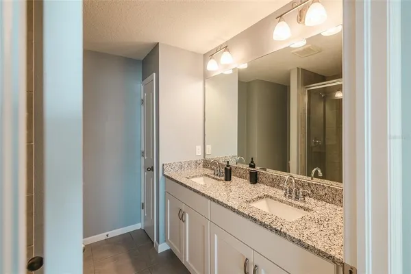a bathroom with a granite countertop sink and a mirror