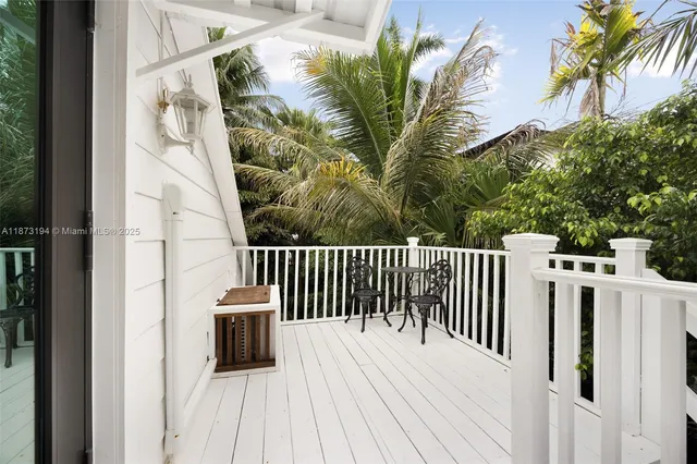 a balcony of a house with wooden floor potted plants and wooden fence