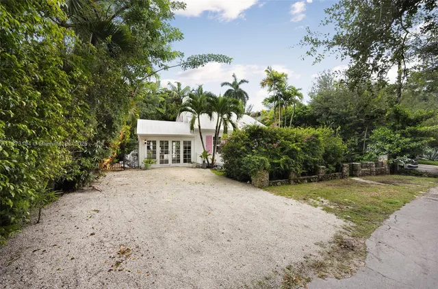 a view of a house with a yard and potted plants