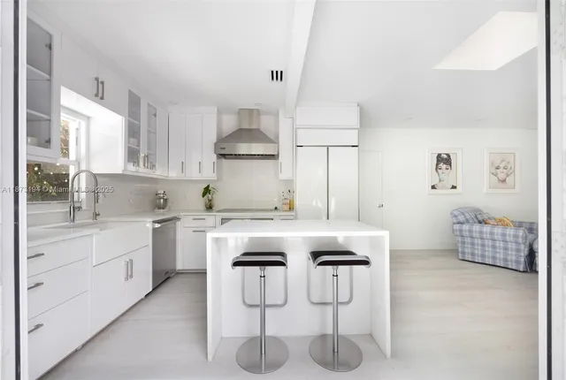 a kitchen with white cabinets and sink