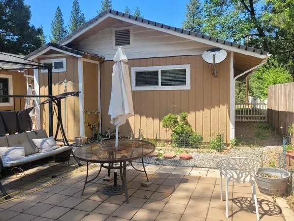 a view of a house with backyard and sitting area