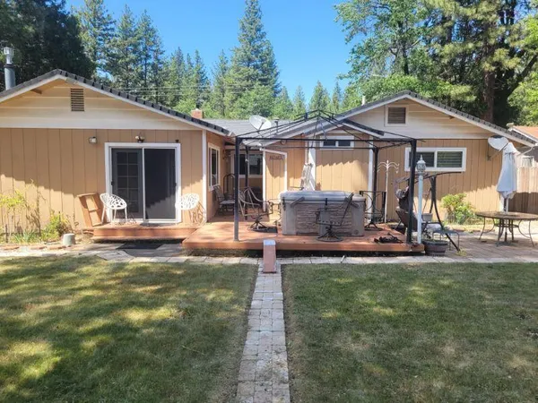 a front view of house with yard and trees in the background