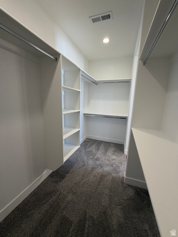 4956 North 925 East, Unit 87 Enoch, UT 84721 - Photo 13 of 19 Spacious walk-in closet featuring built-in shelving, multiple hanging rods, recessed ceiling lighting, and gray carpet flooring