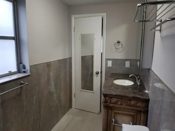 a bathroom with a granite countertop sink and a mirror