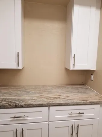 a view of kitchen with granite countertop cabinets and sink