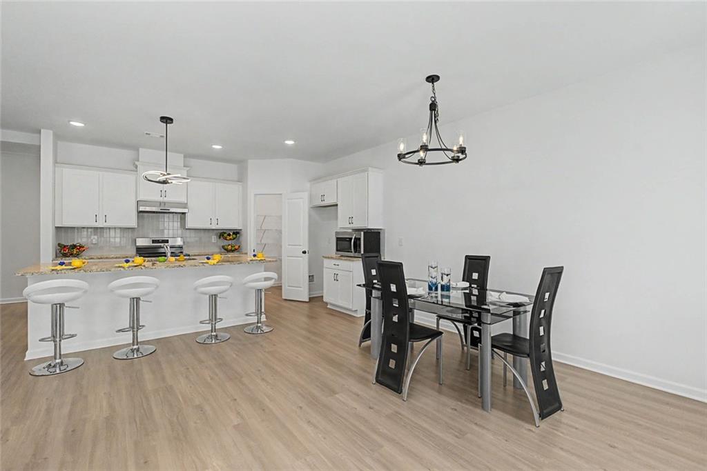 2310 Portrush Way Southeast Atlanta, GA 30339 - Photo 20 of 38 a kitchen with stainless steel appliances a dining table chairs and wooden floor