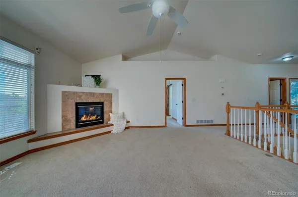 a view of an empty room with fireplace and a window
