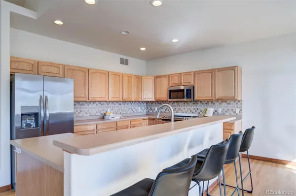 a kitchen with stainless steel appliances granite countertop a sink a stove and a refrigerator