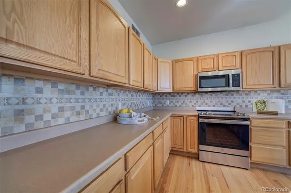 a kitchen with stainless steel appliances granite countertop a sink a stove and cabinets