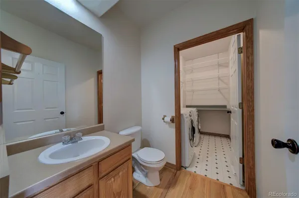a bathroom with a granite countertop toilet a sink and a mirror