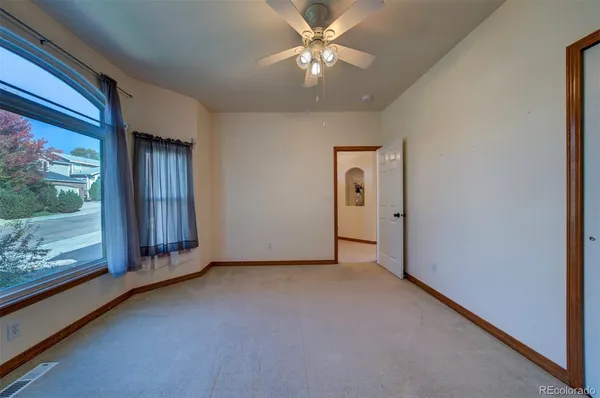 a view of a livingroom with a ceiling fan and window