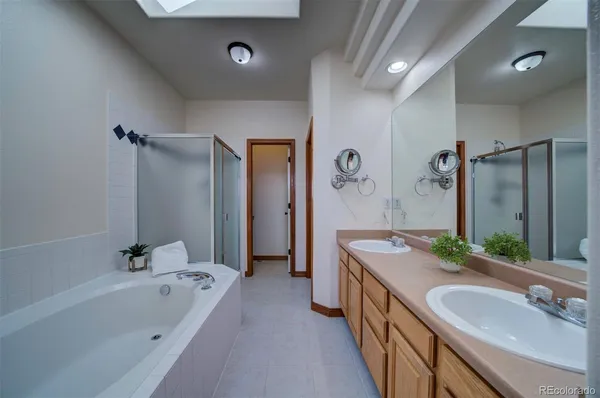 a bathroom with a granite countertop tub sink and mirror