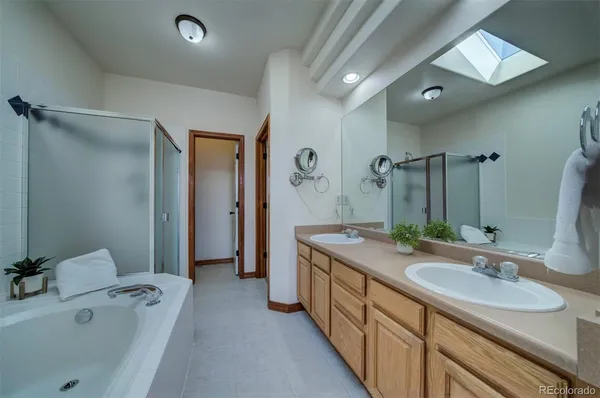 a spacious bathroom with a tub sink and mirror